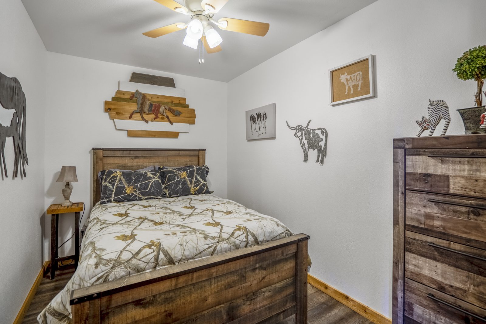 Inspira Ranch barndominium queen bedroom with longhorn and horse western decor