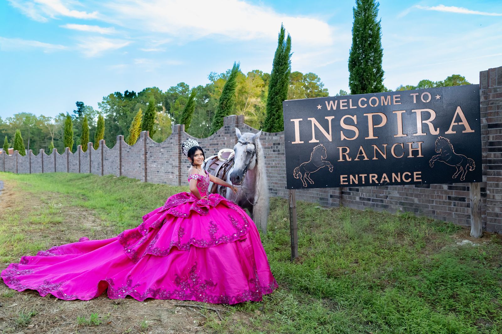 Quinceañera with her white horse at the Welcome to Inspira Ranch entrance sign
