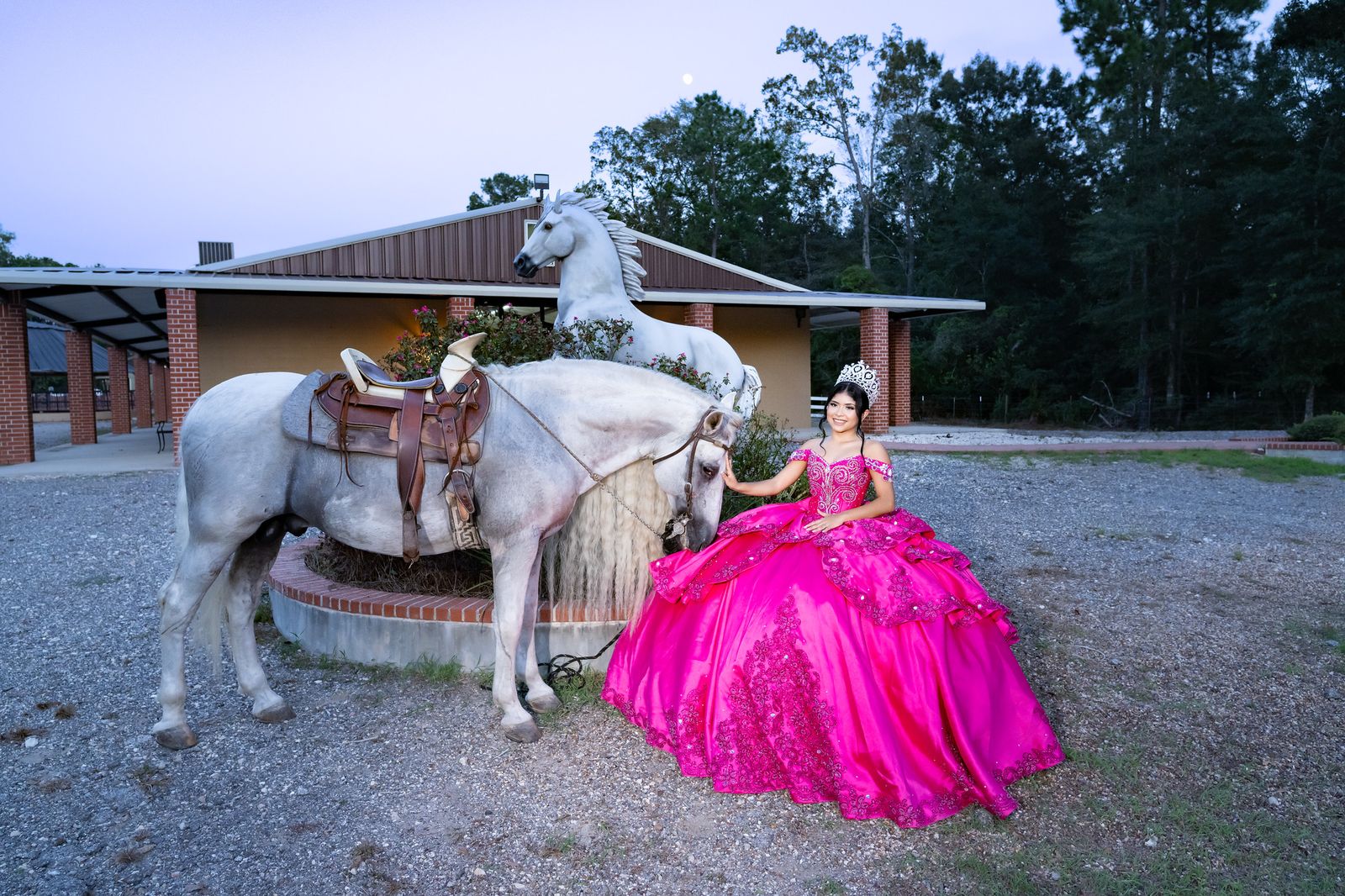 White horse and the ranch's horse statue with a quinceañera in front of the event hall