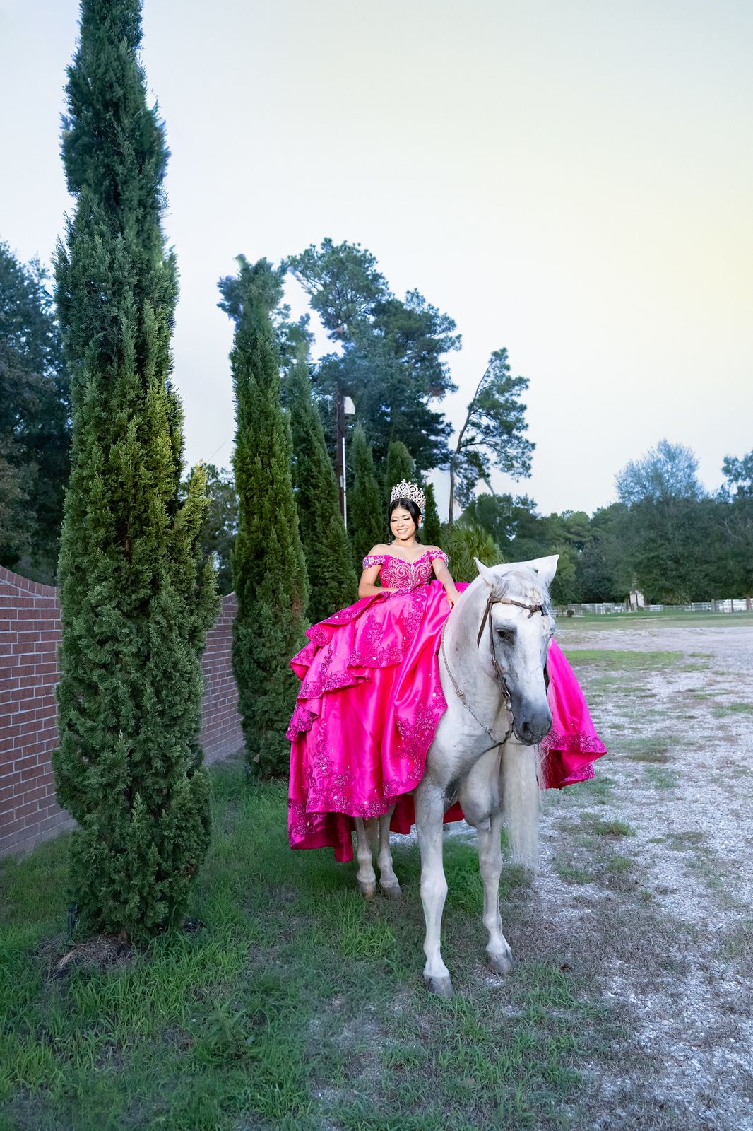 Quinceañera on a white horse with the East Texas tree line behind