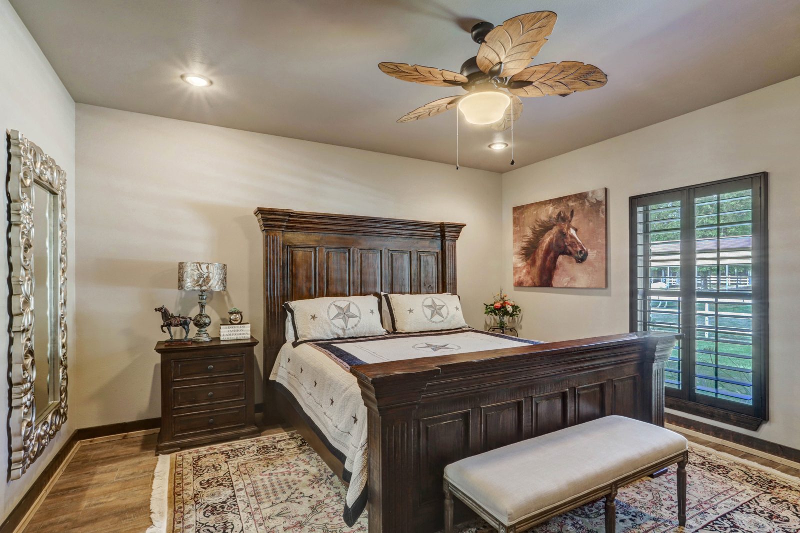 Inspira Ranch main house bedroom with dark wood bed, star motif, and horse artwork