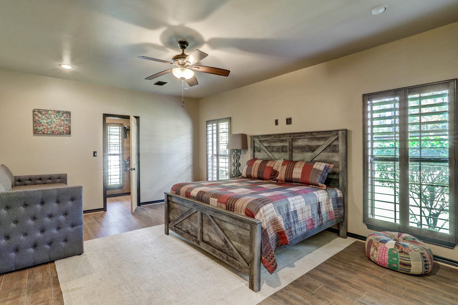 Inspira Ranch main house guest bedroom with barn-door headboard and plaid bedding